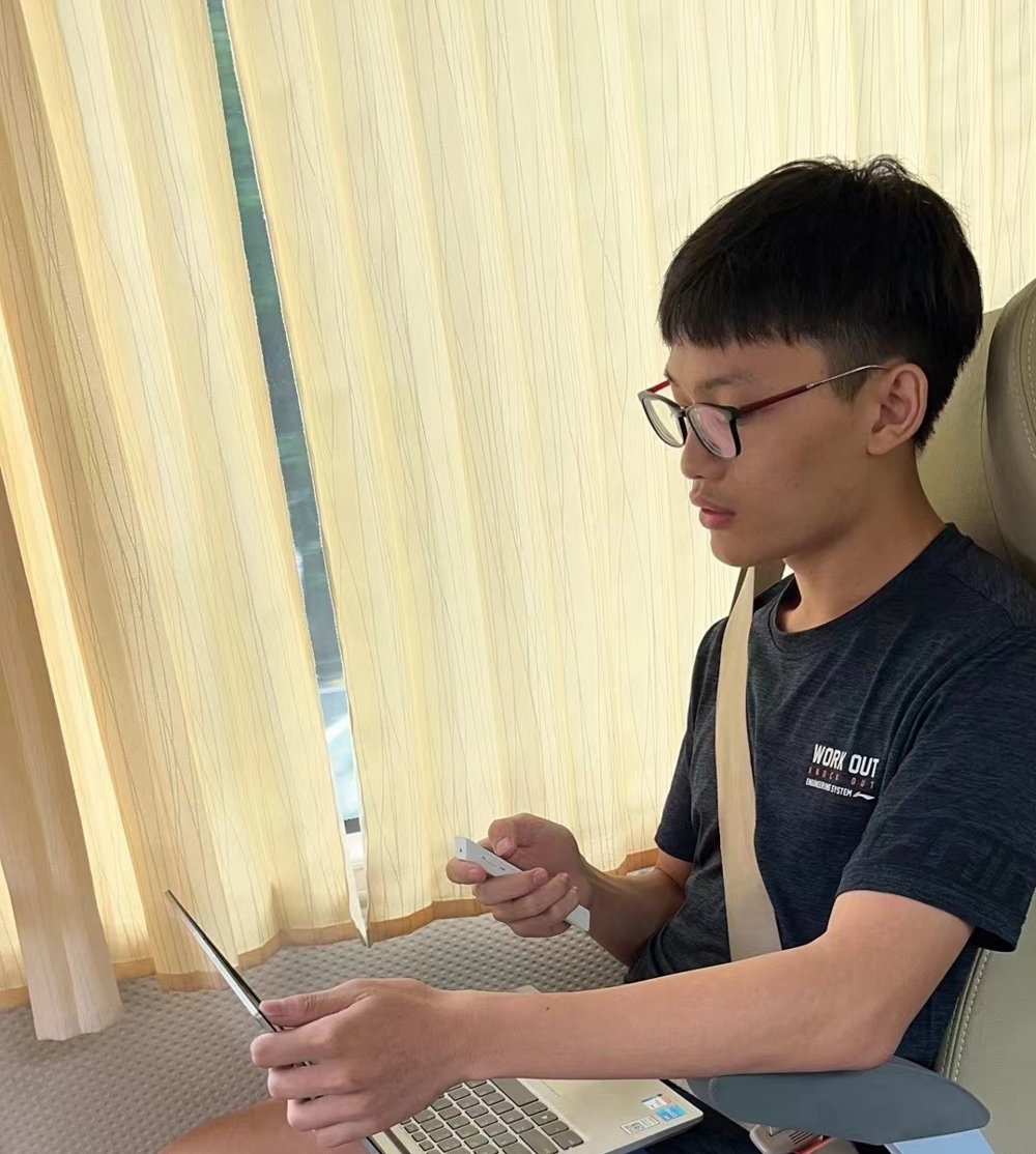 图7 参加省赛路上，吴彦进做路演准备