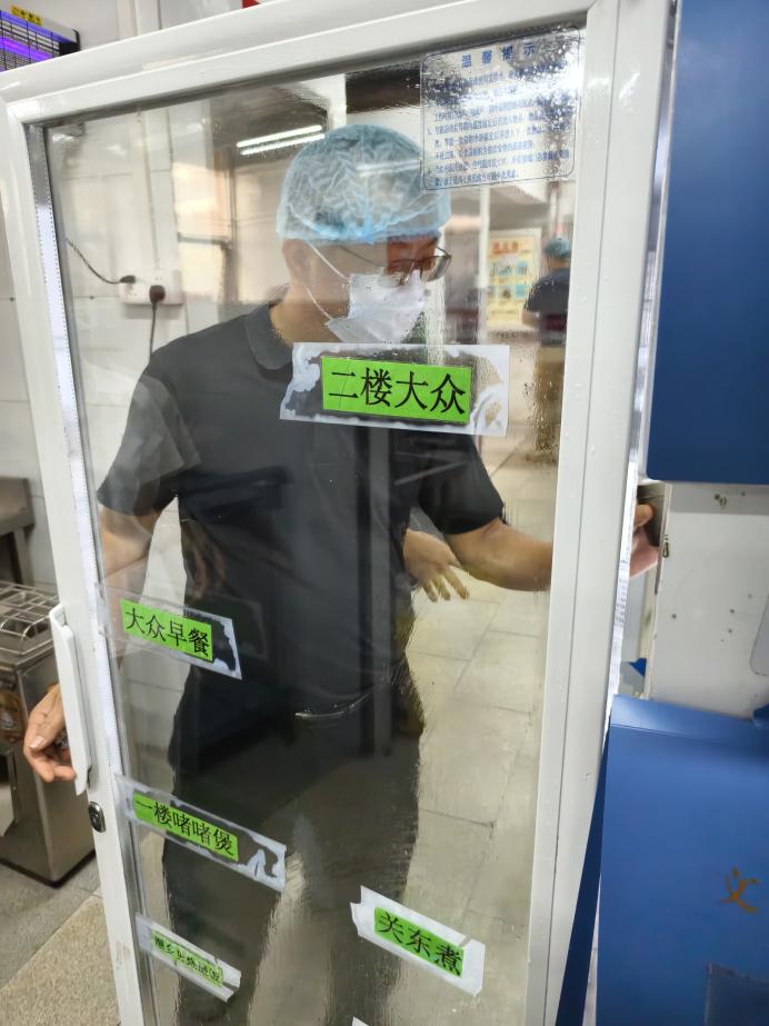 后勤管理处处长许振平检查留样记录