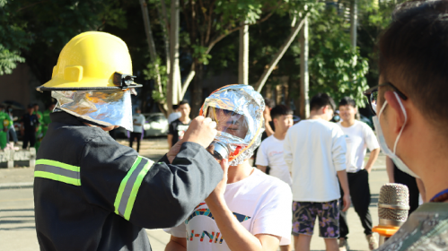图17 消防人员为学生佩戴灭火头盔